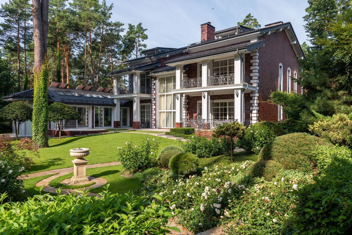 Formal residential garden with clipped hedges in front of a brick home