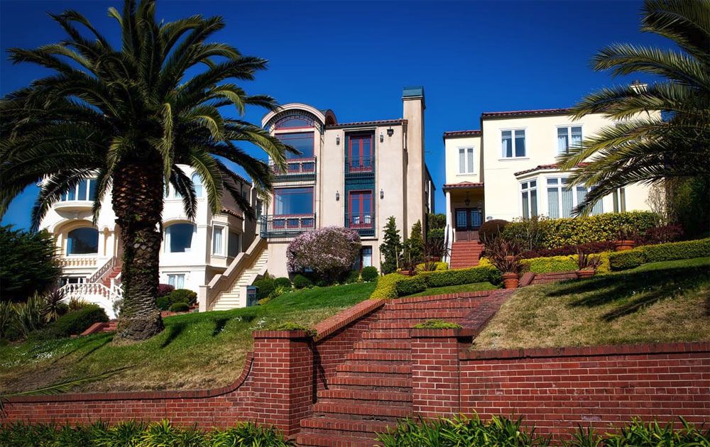 Terraced brick steps and palms leading up to homes